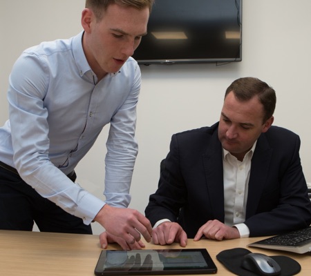 two colleagues reviewing ProGARM website on a tablet